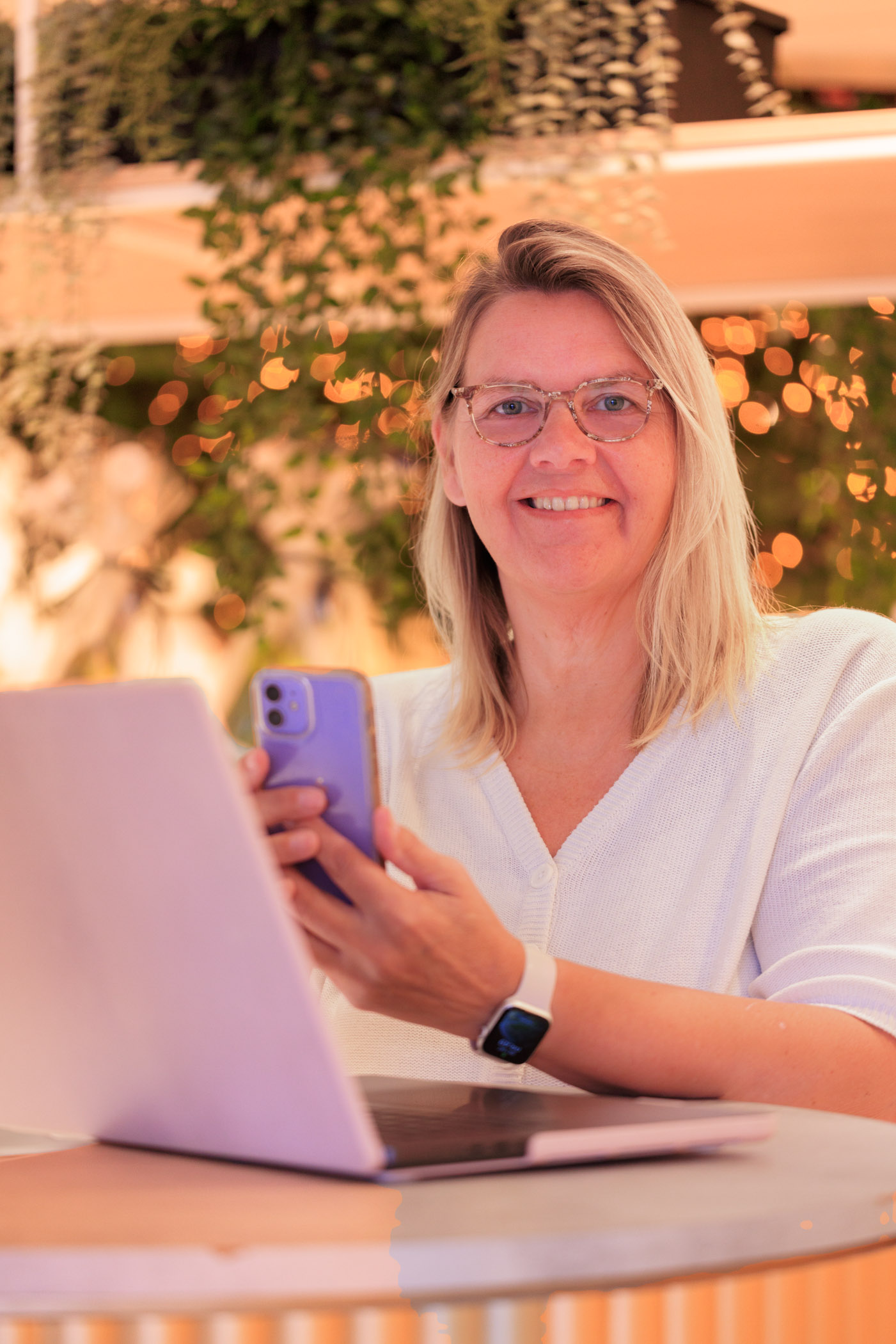 Foto van Monique, eigenaresse van de winkel SwietArts in Hoogvliet. Met laptop en telefoon in beeld